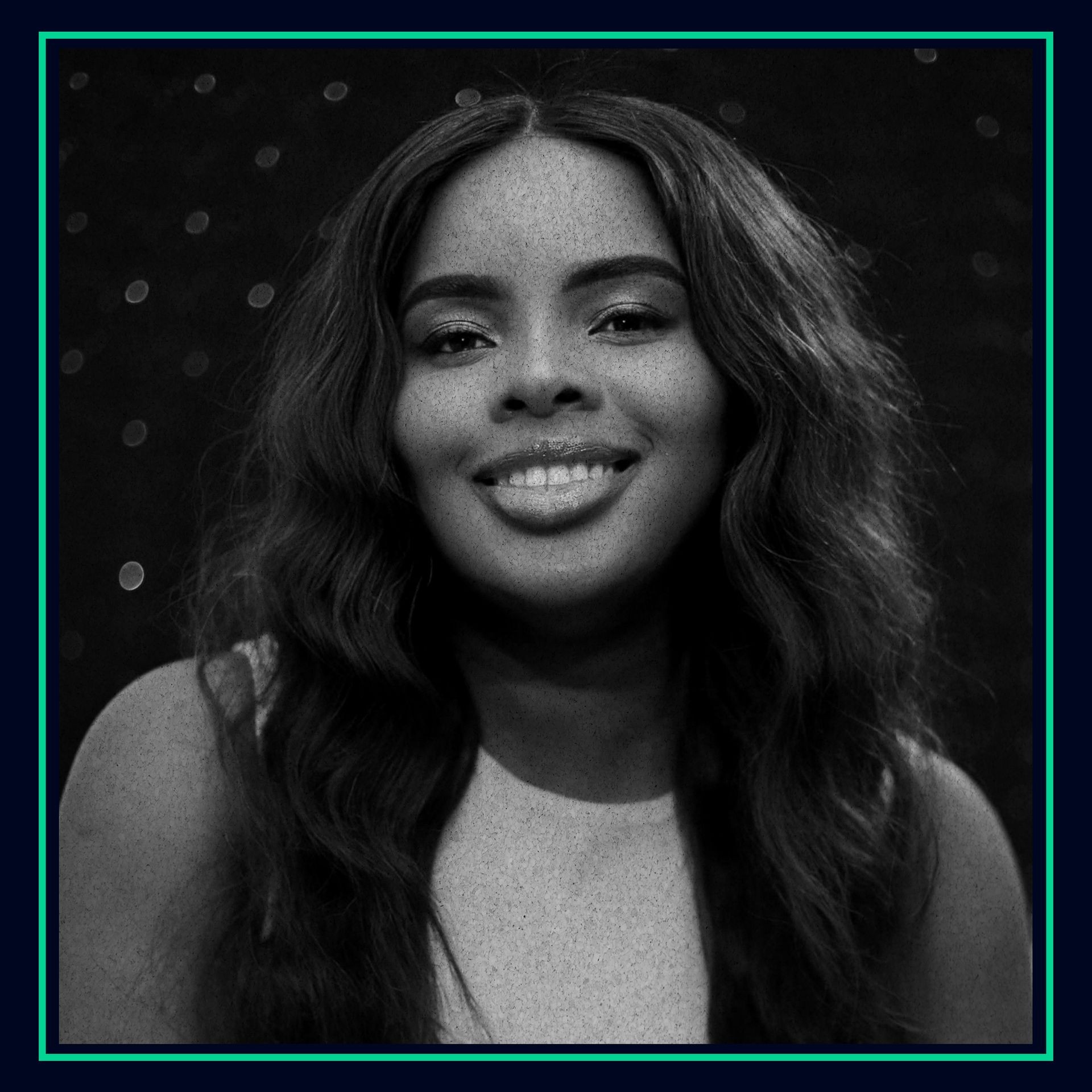 Black and white portrait of a woman smiling against a dark, dotted background.