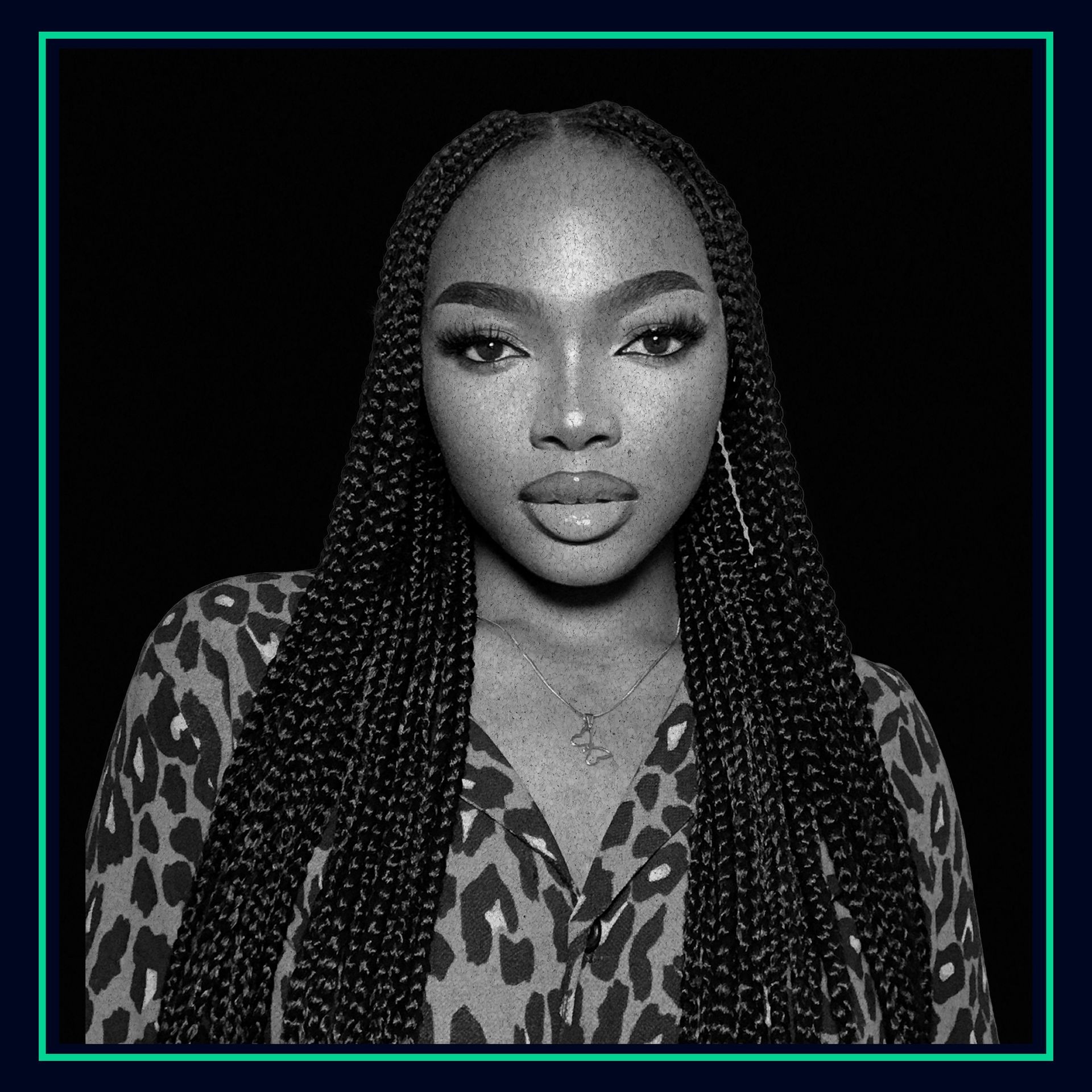 Black and white portrait of a person with long braided hair wearing a leopard print shirt.